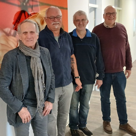 Vier Männer in einem Flur