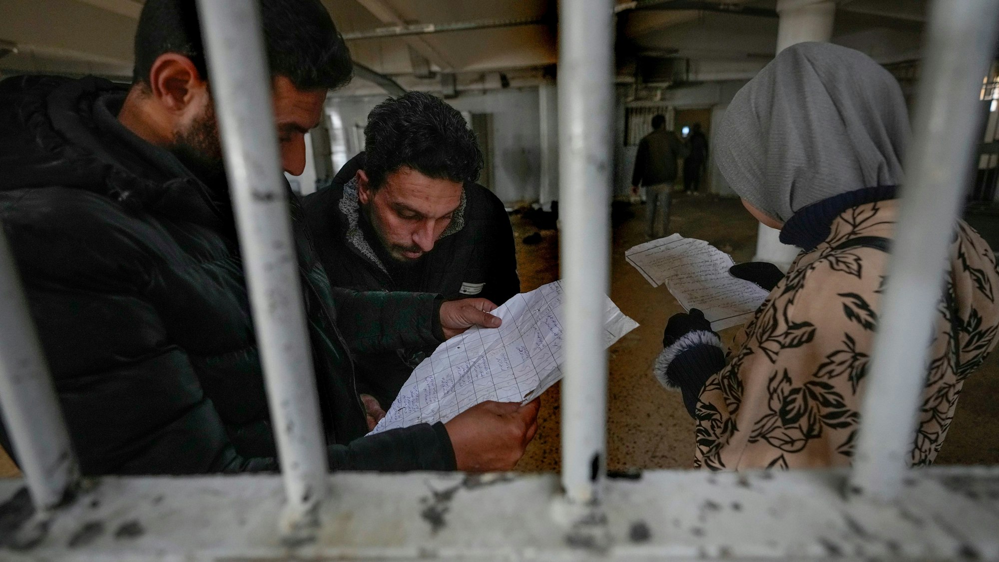 dpatopbilder - 09.12.2024, Syrien, Sednayah: Menschen inspizieren Dokumente, die sie im berüchtigten Saydnaya-Militärgefängnis nördlich von Damaskus gefunden haben.