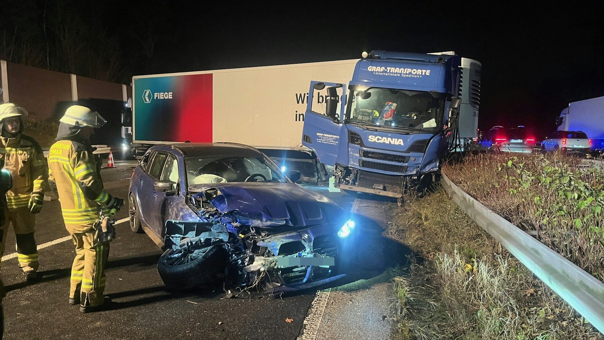 Ein Pkw und ein Lkw stehen mit deutlichen Unfallspuren an der Leitplanke.