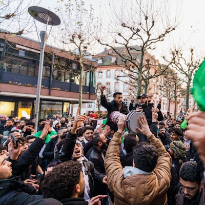 Exil-Syrer feiern in Mainz den Sturz des Assad-Regimes und schwenken dabei die syrische Nationalflagge.