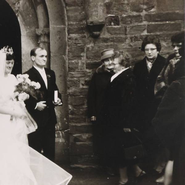 Ein Hochzeitspaar vor der Kirche in Waldbröl. Das Foto ist ein altes schwarz-weißes Foto.