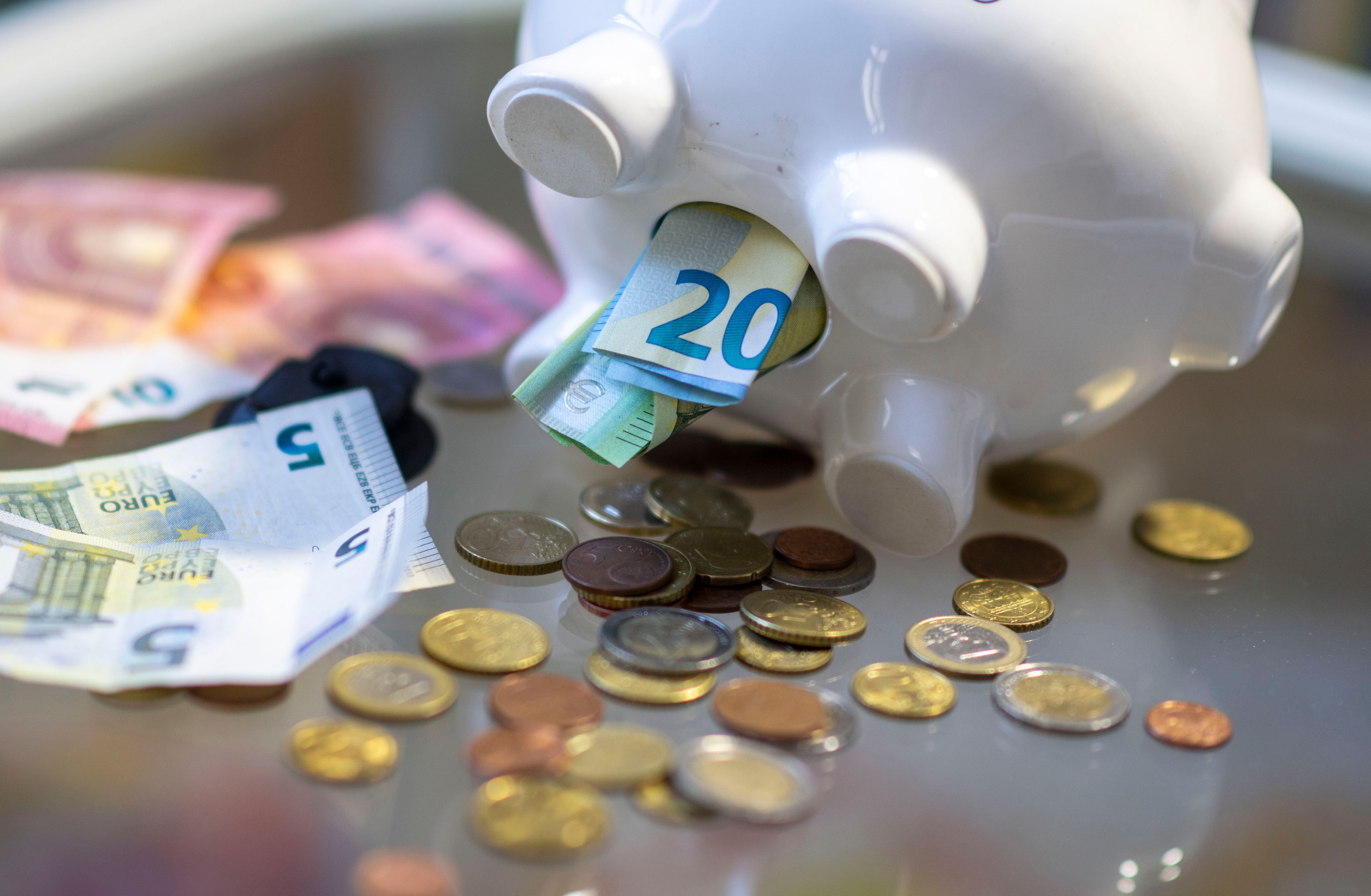 Geld steckt im Bauch eines Sparschweins. Am 30. Oktober ist Weltspartag.