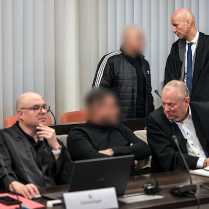 dpatopbilder - 10.12.2024, Nordrhein-Westfalen, Wuppertal: Der Hauptangeklagte (hinten, links) spricht im Gerichtssaal mit seinem Verteidiger Oliver Doelfs (hinten, rechts), während vorne ein Angeklagter (M) mit seinem Verteidiger Hartmut Moyzio (vorne, rechts) spricht. In Wuppertal hat der Prozess wegen eines Erpressungsversuchs gegen die Familie von Ex-Formel-1-Weltmeister Michael Schumacher begonnen. Angeklagt sind drei 30 bis 53 Jahre alte Männer. Dem Haupttäter wird versuchte Erpressung in einem besonders schweren Fall vorgeworfen, den beiden anderen Beihilfe dazu. Foto: Oliver Berg/dpa - ACHTUNG: Person(en) wurde(n) aus rechtlichen Gründen gepixelt +++ dpa-Bildfunk +++