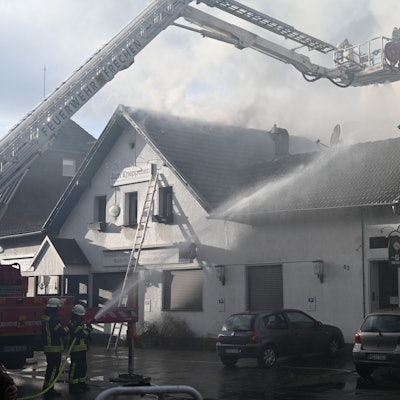 Das Foto zeigt ein Haus, das von der Feuerwehr gelöscht wird.