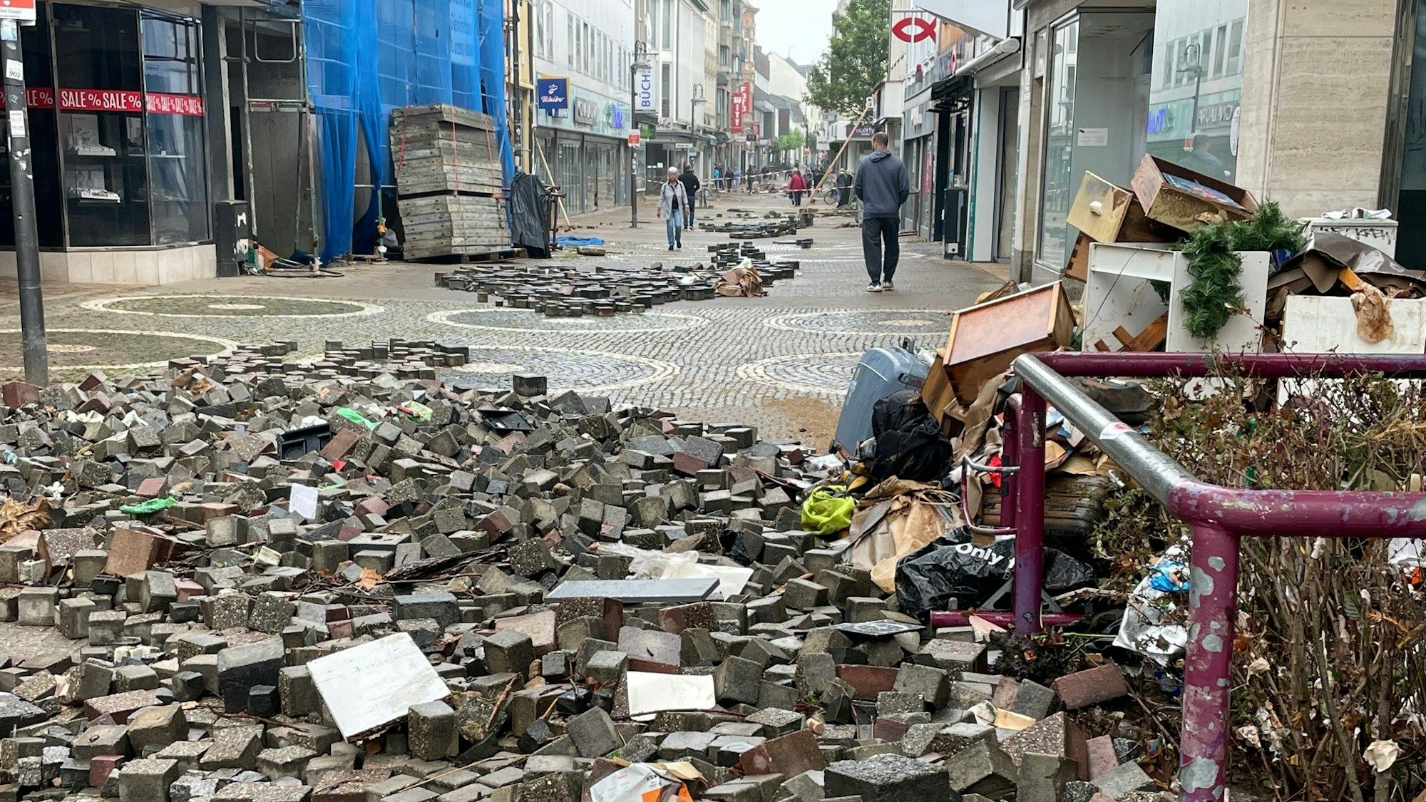 Straßensteine, die durch die Flut aus der Erde gehoben wurden, liegen in der Euskirchener Fußgängerzone. (Archivfoto)