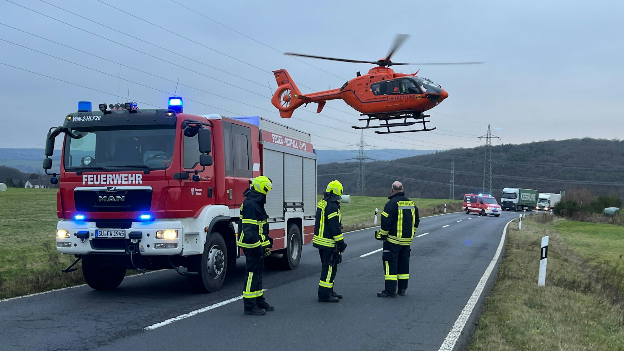 Ein Hubschrauber startet hinter einem Feuerwehrauto.