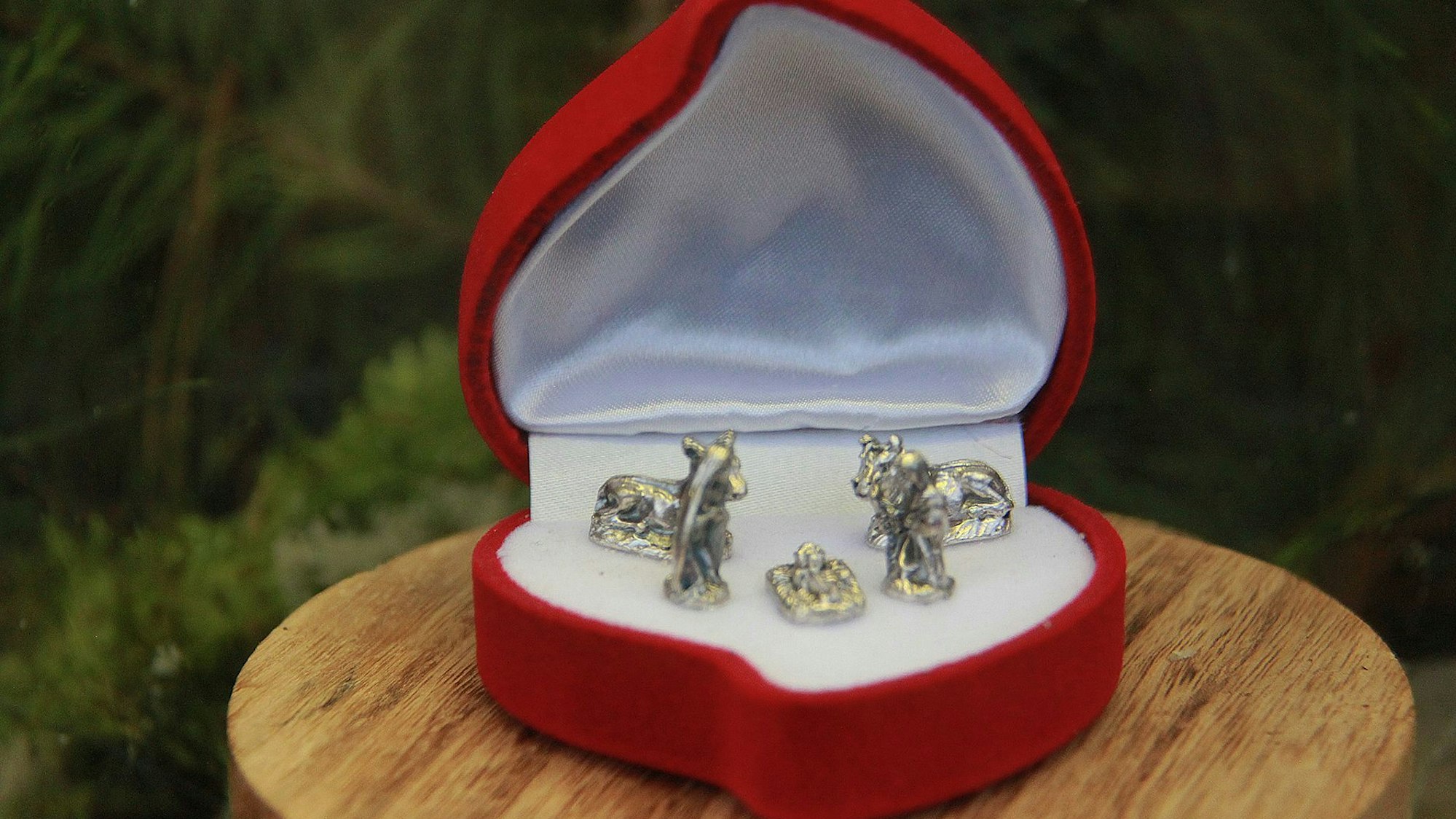In der kleinen Schatulle, die in einer Hand Platz hätte, sind silberne Figuren zu sehen.