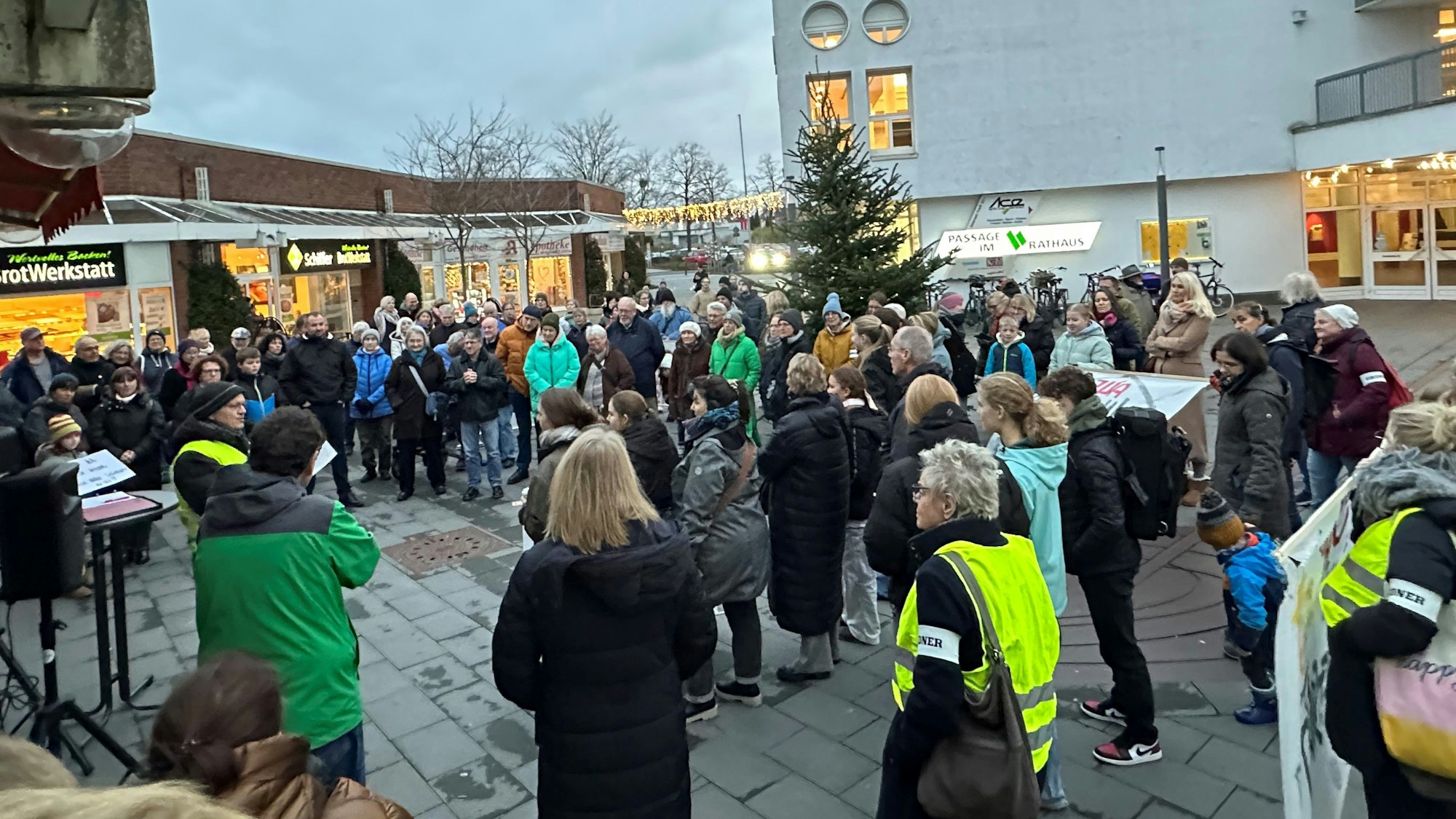 Menschen stehen auf einem Platz.