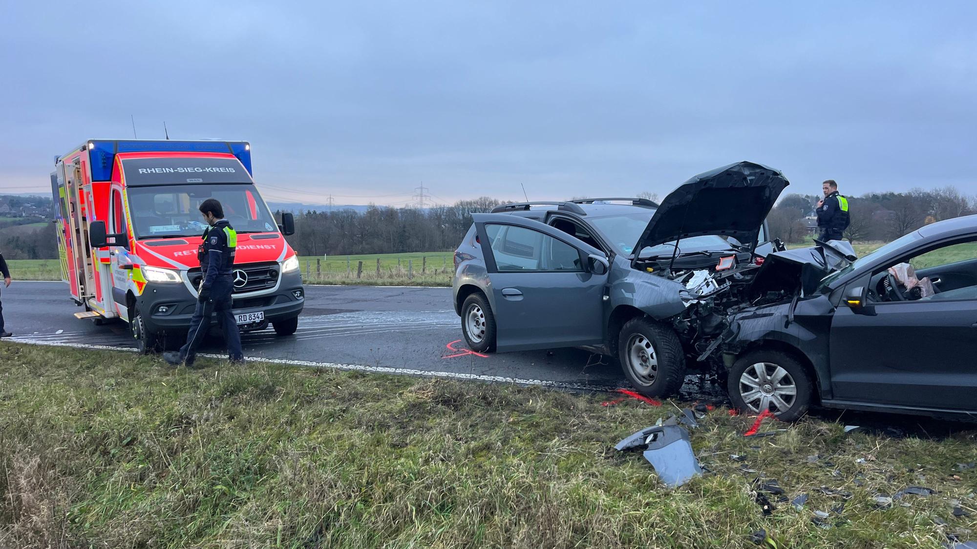 Zwei zusammengestoßene Autos stehen neben einem Rettungswagen.