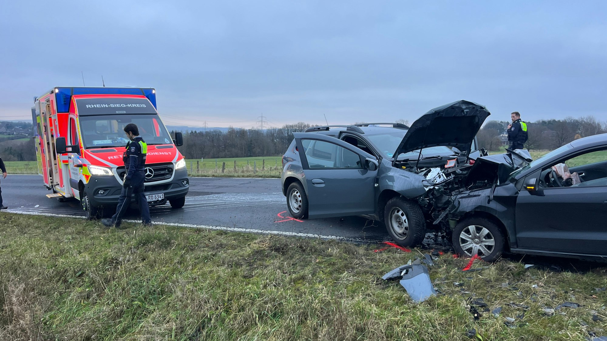 Zwei zusammengestoßene Autos stehen neben einem Rettungswagen.