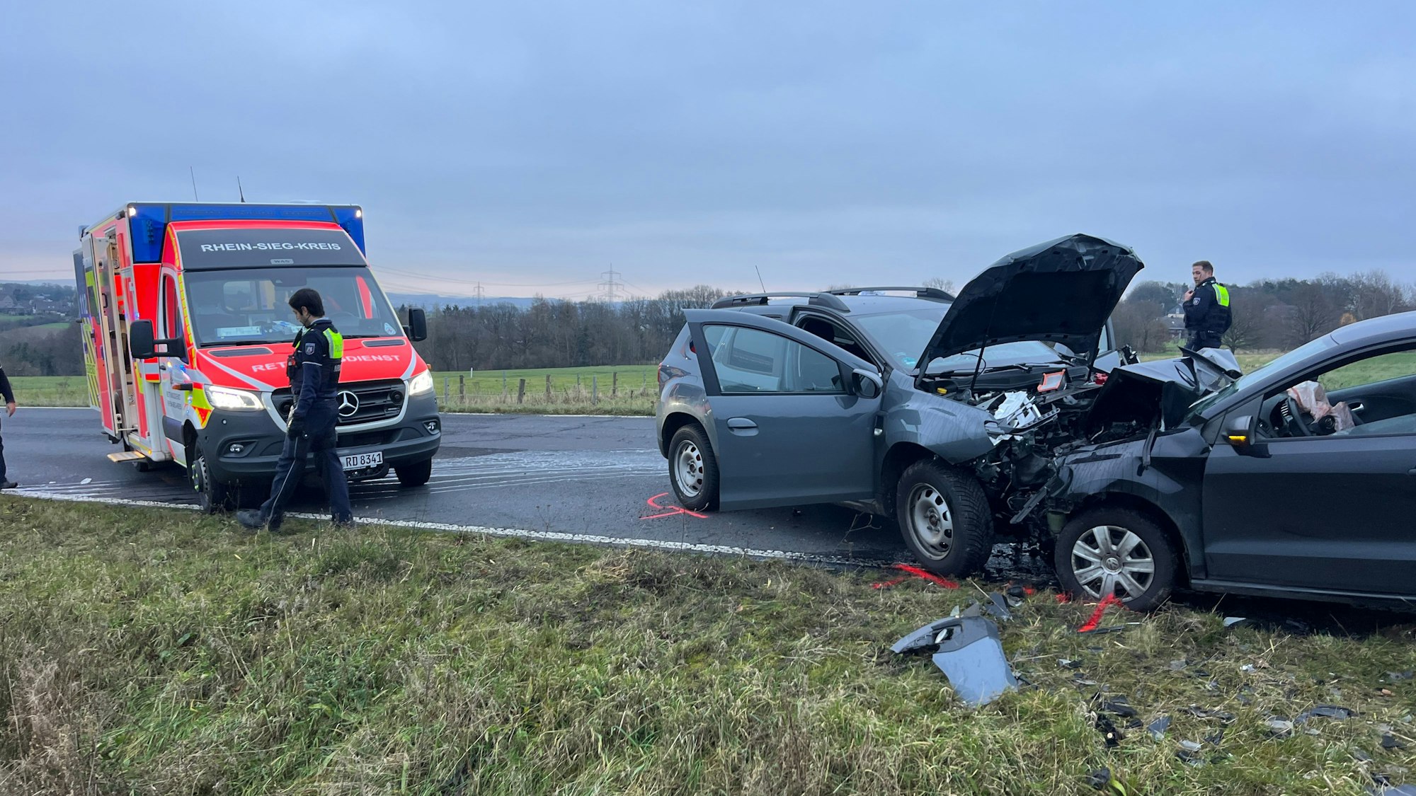 Zwei zusammengestoßene Autos stehen neben einem Rettungswagen.