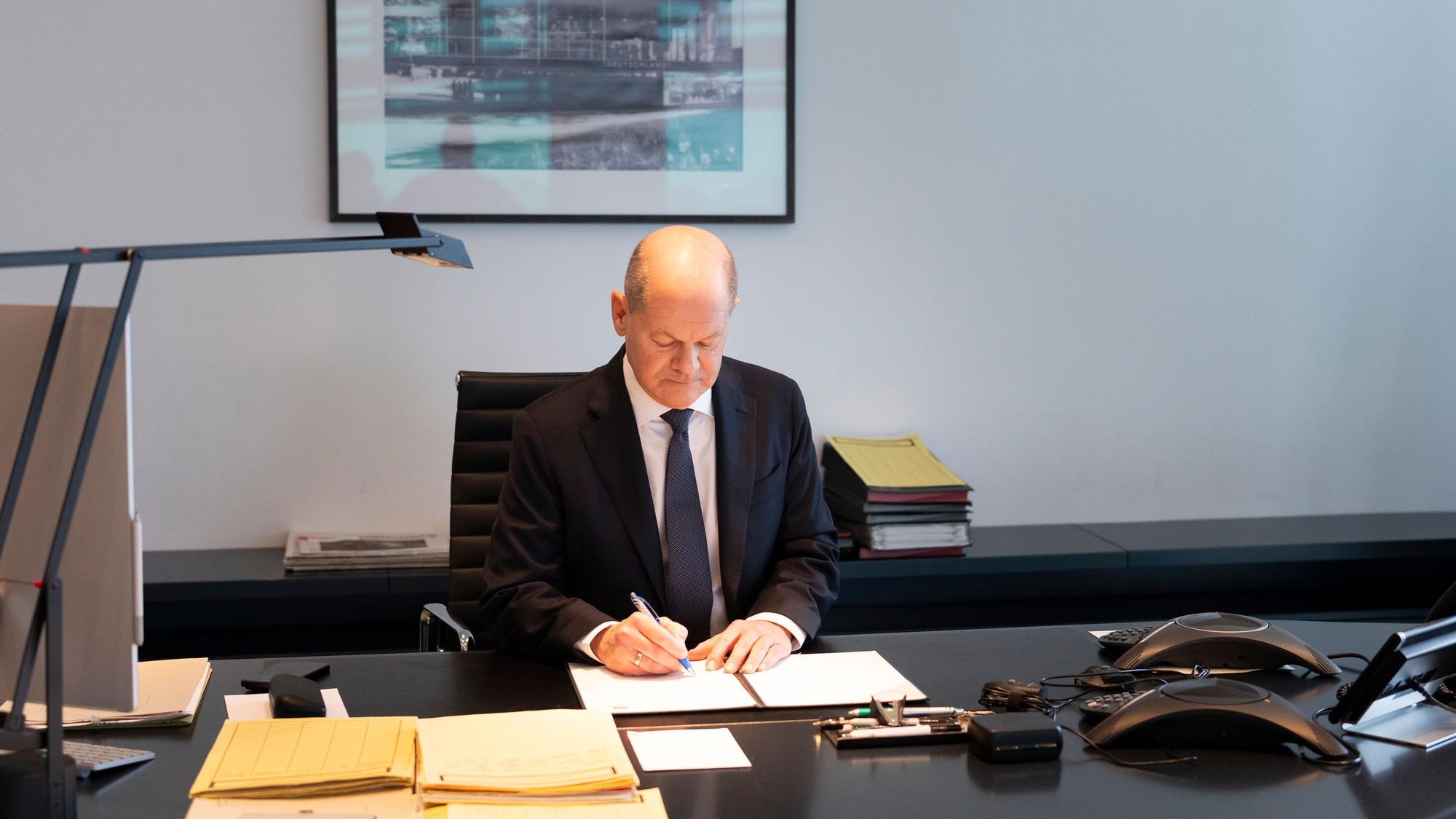 Bundeskanzler Olaf Scholz unterzeichnet den Antrag auf Vertrauen an die Bundestagspräsidentin in seinem Büro im Bundeskanzleramt.