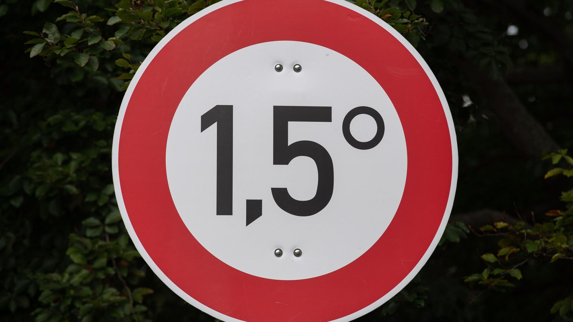 ARCHIV - 03.10.2021, Berlin: Mit diesem Schild machen Klima-Aktivisten unweit des Hauses der Kulturen der Welt auf das Ziel des Pariser Klimaabkommens aufmerksam, den globalen Temperaturanstieg auf 1,5 Grad gegenüber der vorindustriellen Zeit zu begrenzen. Schätzungsweise 20 Klima-Aktivisten haben auf einer Wiese das «Klima Gerechtigkeitscamp» errichtet. Dort wollen sie mindestens bis Ende Oktober bleiben. (zu dpa: «KI-Prognosen: Erderwärmung könnte schneller voranschreiten») Foto: Paul Zinken/dpa +++ dpa-Bildfunk +++