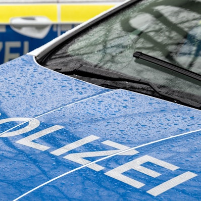 Das Foto zeigt den Schriftzug Polizei auf der Kühlerhaube eines Autos.