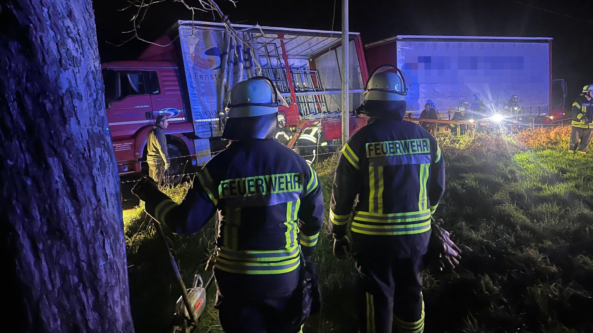 Feuerwehrleute stehen vor einem Lastwagen, der umzukippen drohte.