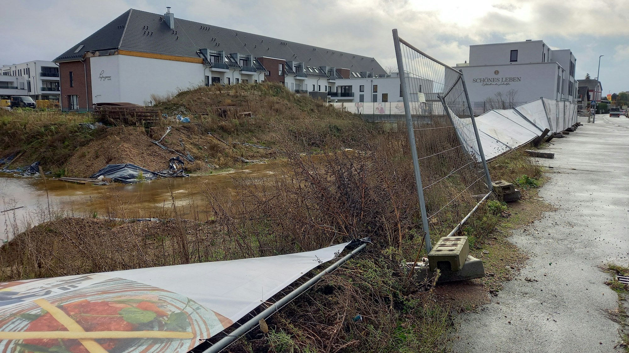 Das Foto zeigt die Baugrube und den teilweise umgestürzten Bauzaun.