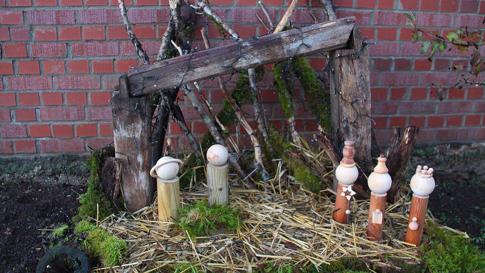 Auf Stroh stehen fünf Figuren, dahinter ein Holzgestell, das den Stall darstellt.