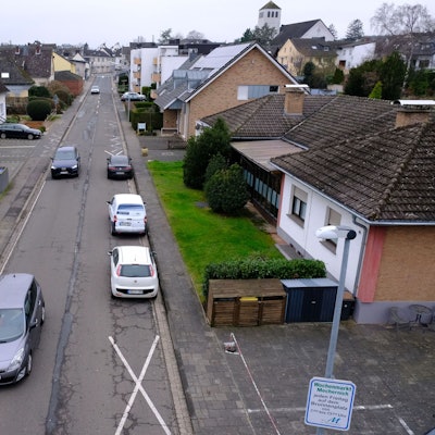 Die Feytalstraße in Mechernich führt von der Ortsmitte zum Schulzentrum. Am rechten Straßenrand parken drei Autos auf der Fahrbahn.