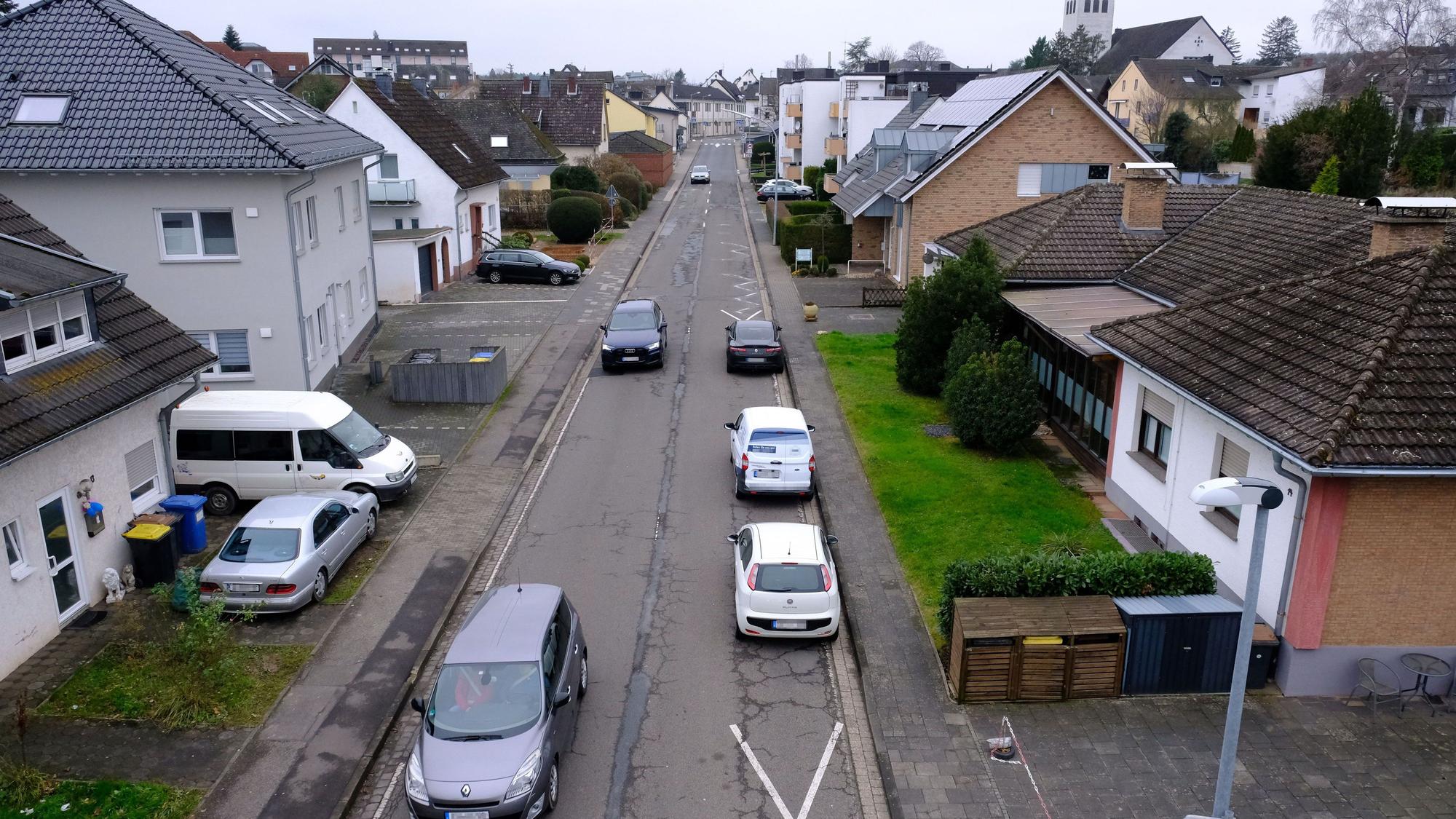 Die Feytalstraße in Mechernich führt von der Ortsmitte zum Schulzentrum. Am rechten Straßenrand parken drei Autos auf der Fahrbahn.