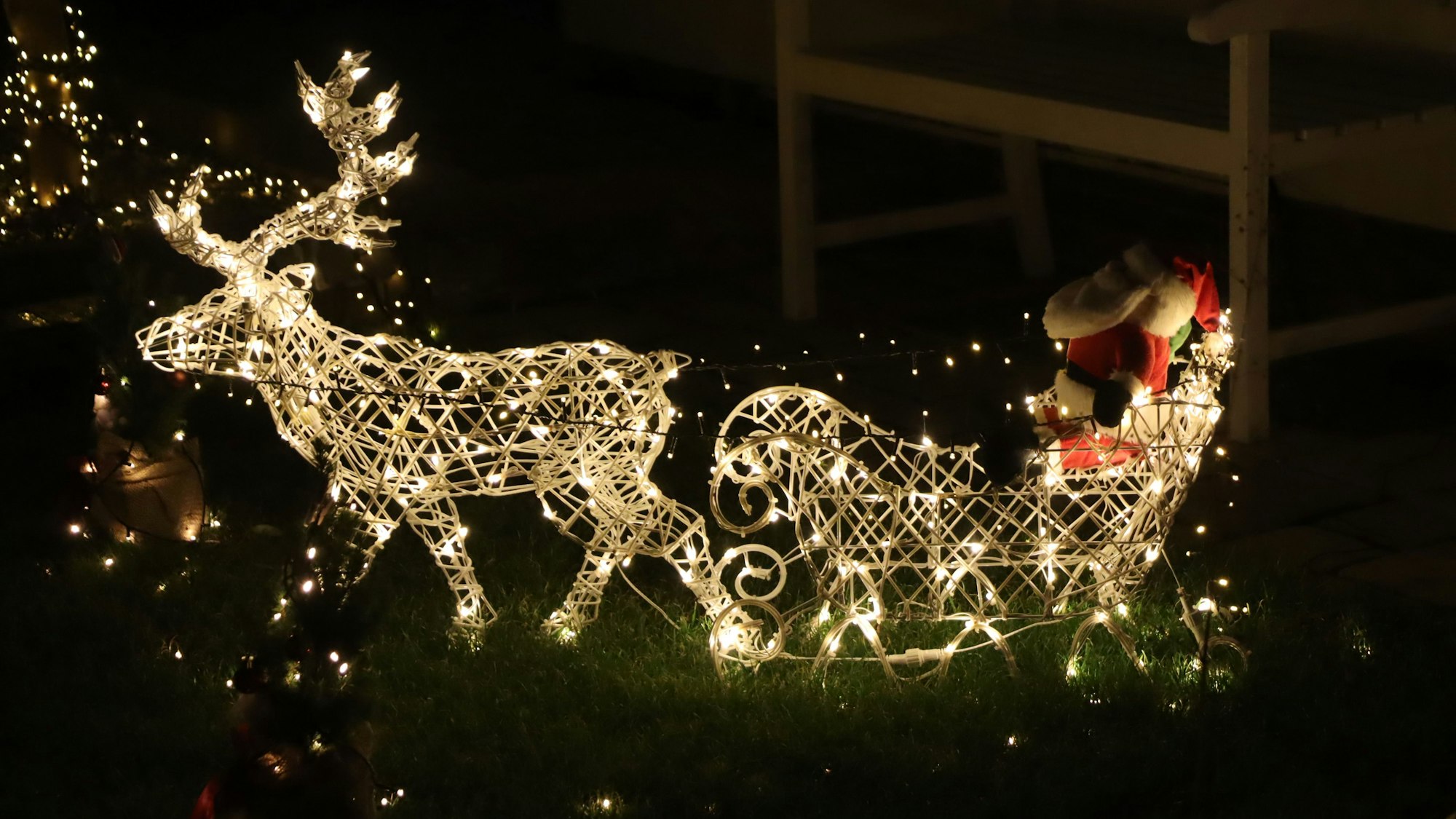 Ein beleuchteter Schlitten mit Weihnachtsman, gezogen von einem Rentier.
