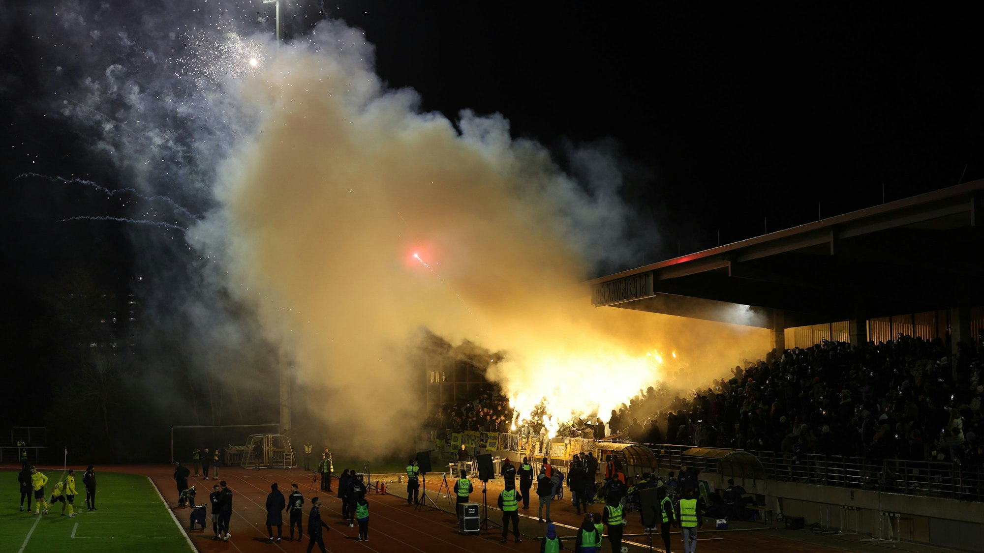 Die Aachener Fans brennen Pyrotechnik ab.