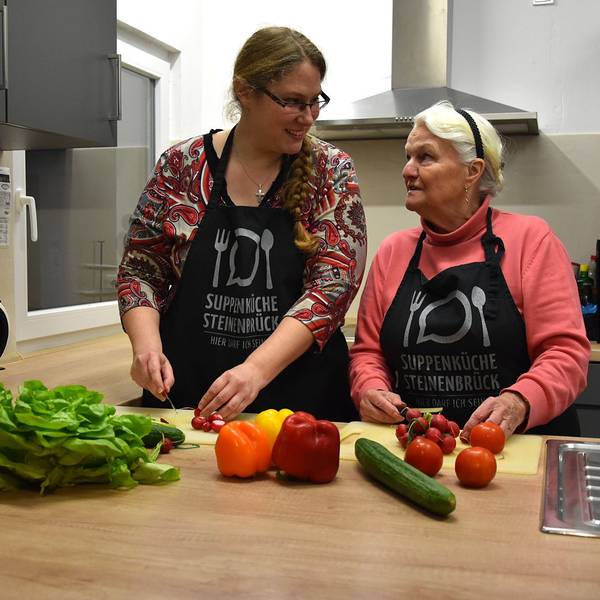 Gemeinsam schnippeln Leiterin Maike Wittenburg und die Ehrenamtliche Helga Herzog in einer Küche Gemüse für einen bunten Salat.