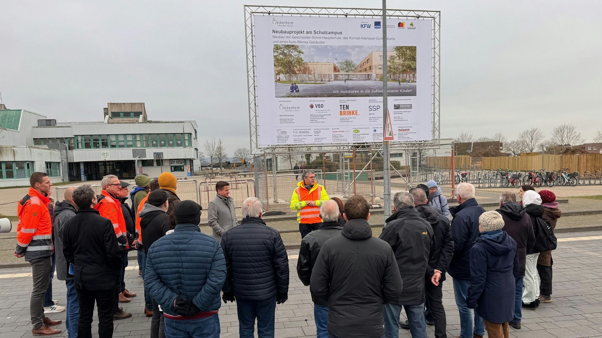 Andreas Satzer (mit Warnweste) steht vor der Gruppe und erklärt den Baufortschritt.
