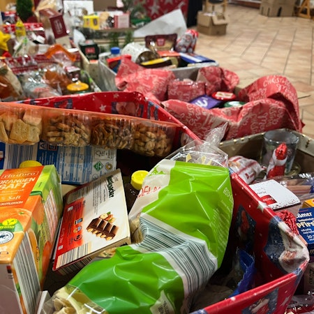 In geschmückten Kartons sind Lebensmittel verpackt.