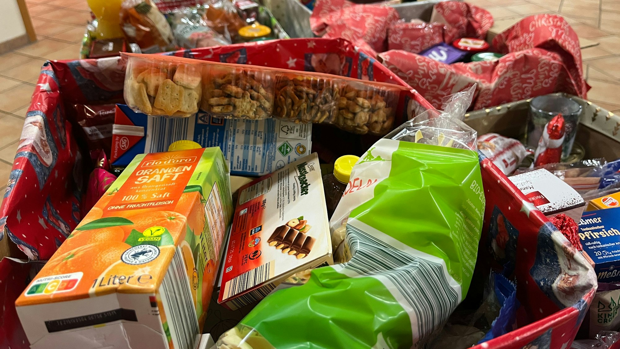 In geschmückten Kartons sind Lebensmittel verpackt.