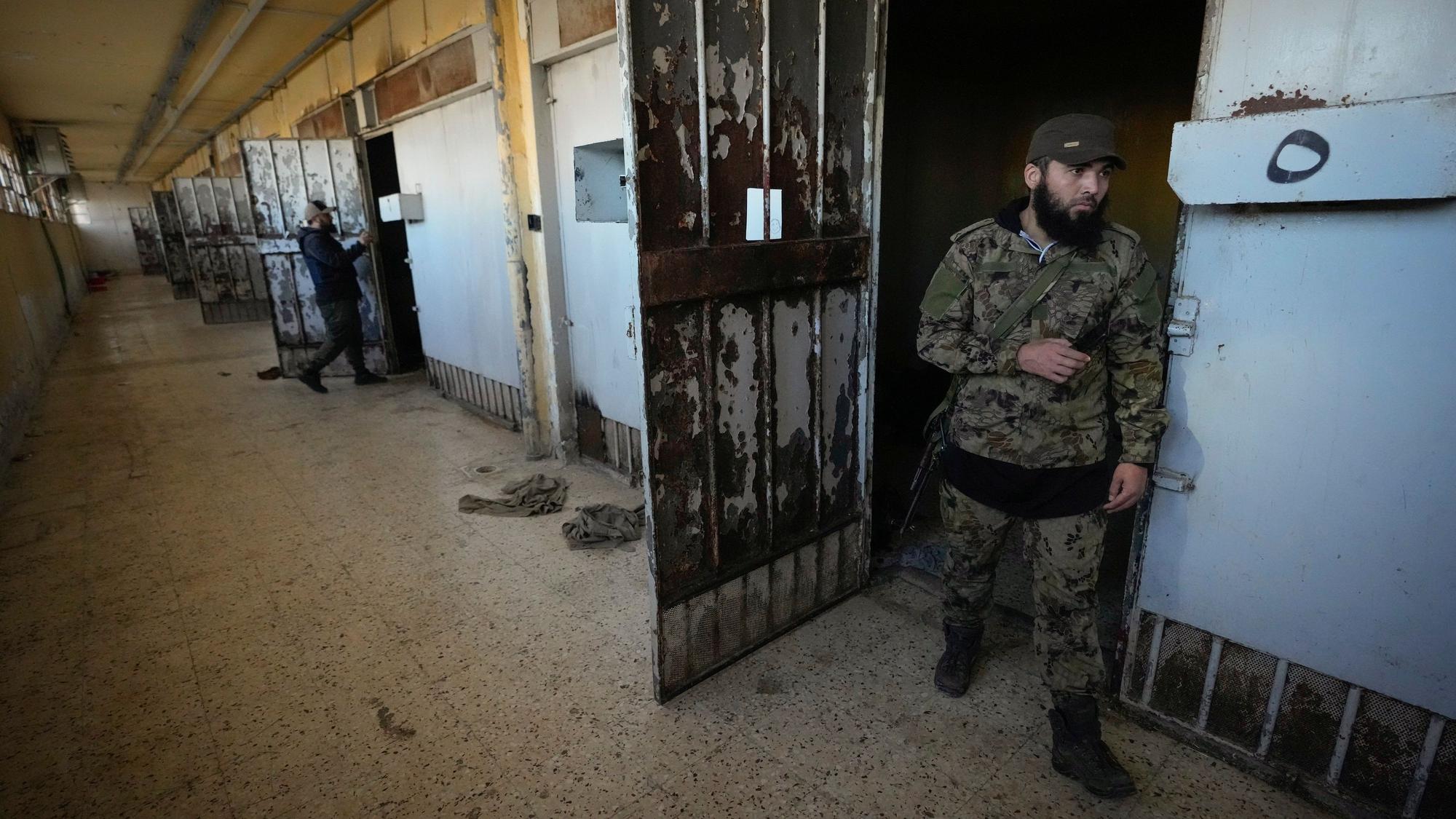 09.12.2024, Syrien, Sednayah: Zwei aufständische Kämpfer inspizieren die Zellen des berüchtigten Militärgefängnisses Saidnaja nördlich von Damaskus.