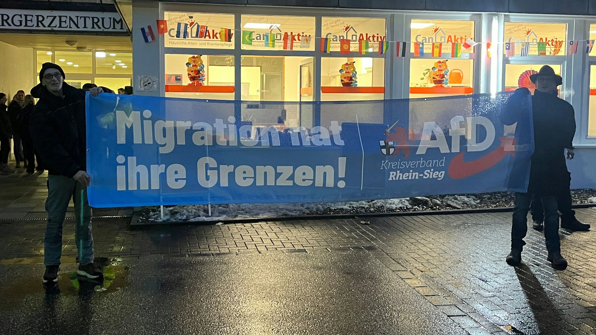 Zwei Männer mit einem blauen AfD-Transparent.