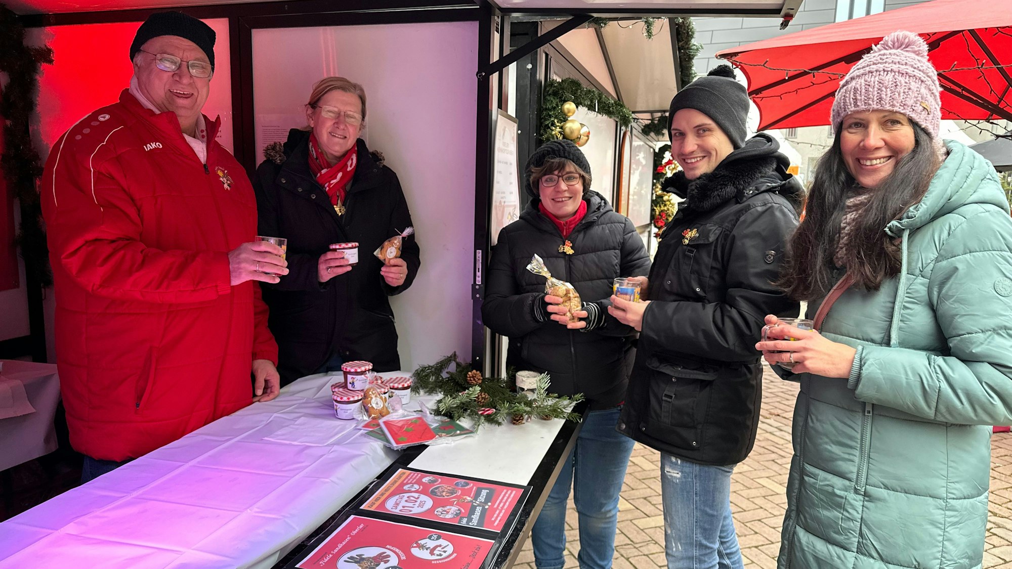 Der Stand der Karnevalsgesellschaft Fidele Sandhasen Oberlar im Innenhof von Burg Wissem in Troisdorf trinken Besucher heißen Glühwein.