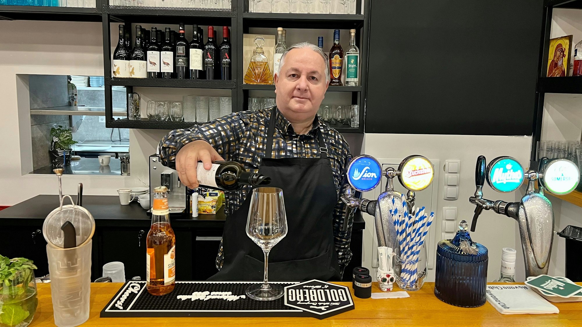 Andreas Dimitriou steht hinter der Theke seines Restaurants Plomari Garden am Klettenberggürtel.