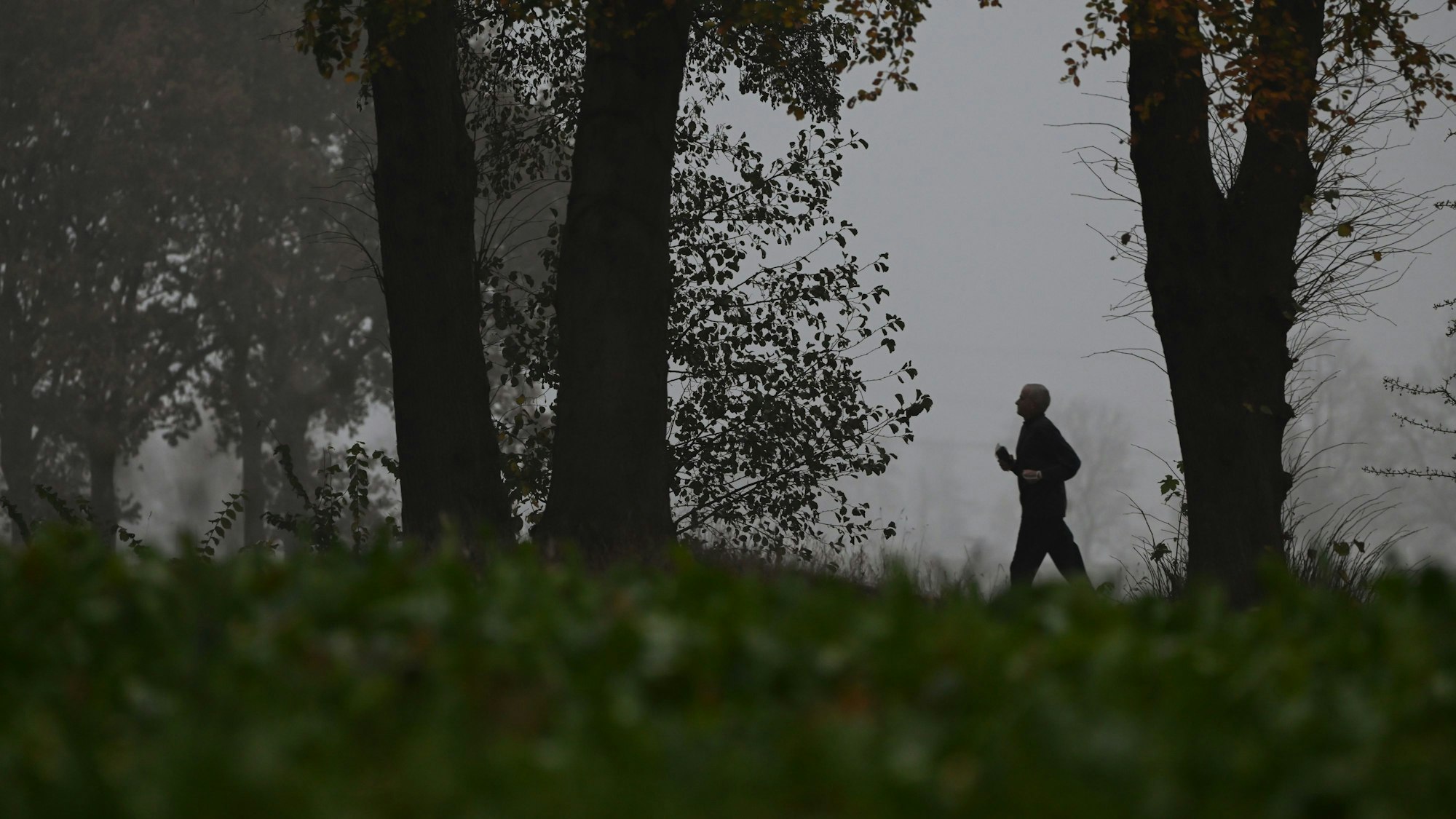 Ein Jogger joggt bei diesigem Wetter