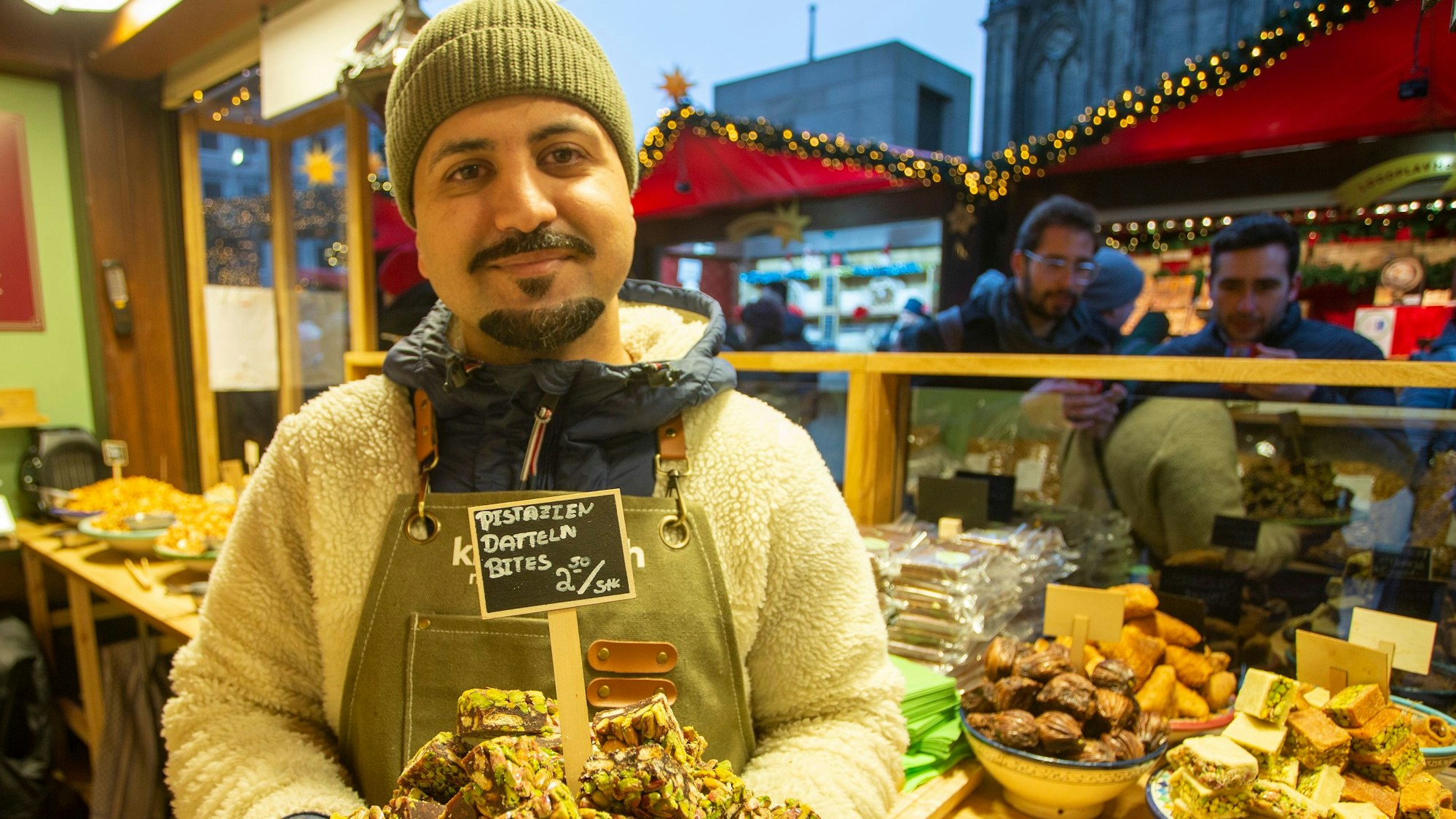 Standinhaber Nasrat Kushkaki hält ein Tablett mit Pistazien.