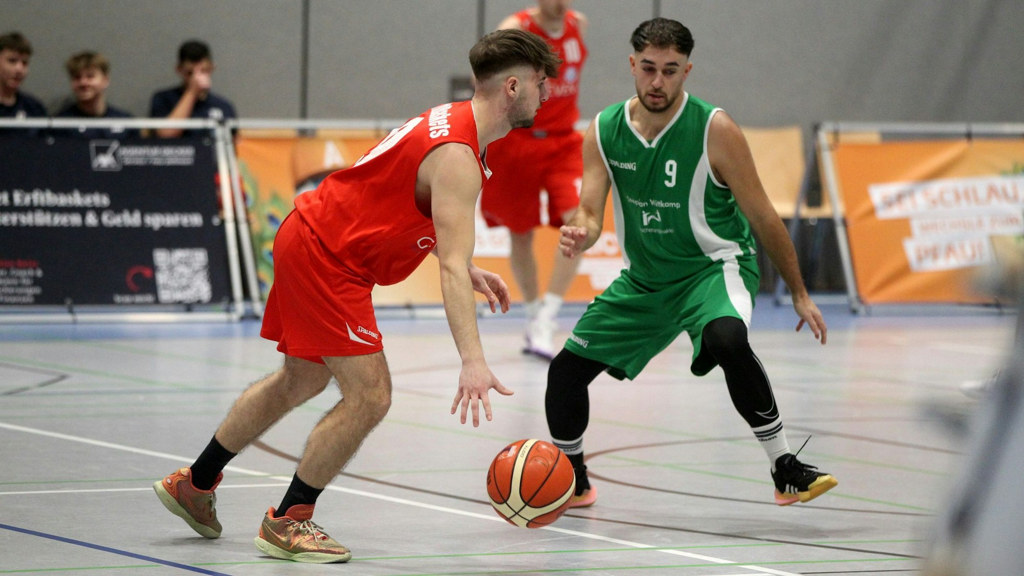 Ein Basketballer dribbelt auf einen Gegner zu. Der Ball befindet sich fast auf dem Boden.