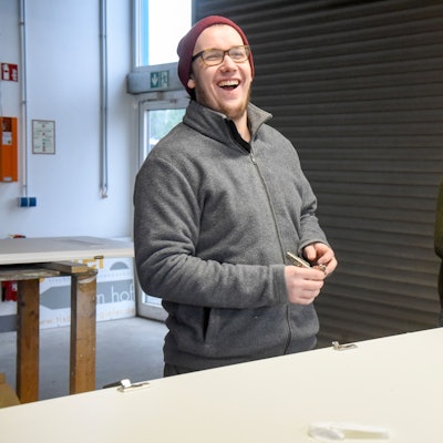 Auf dem Bild sind zwei Handwerker in der Werkstatt zu sehen.