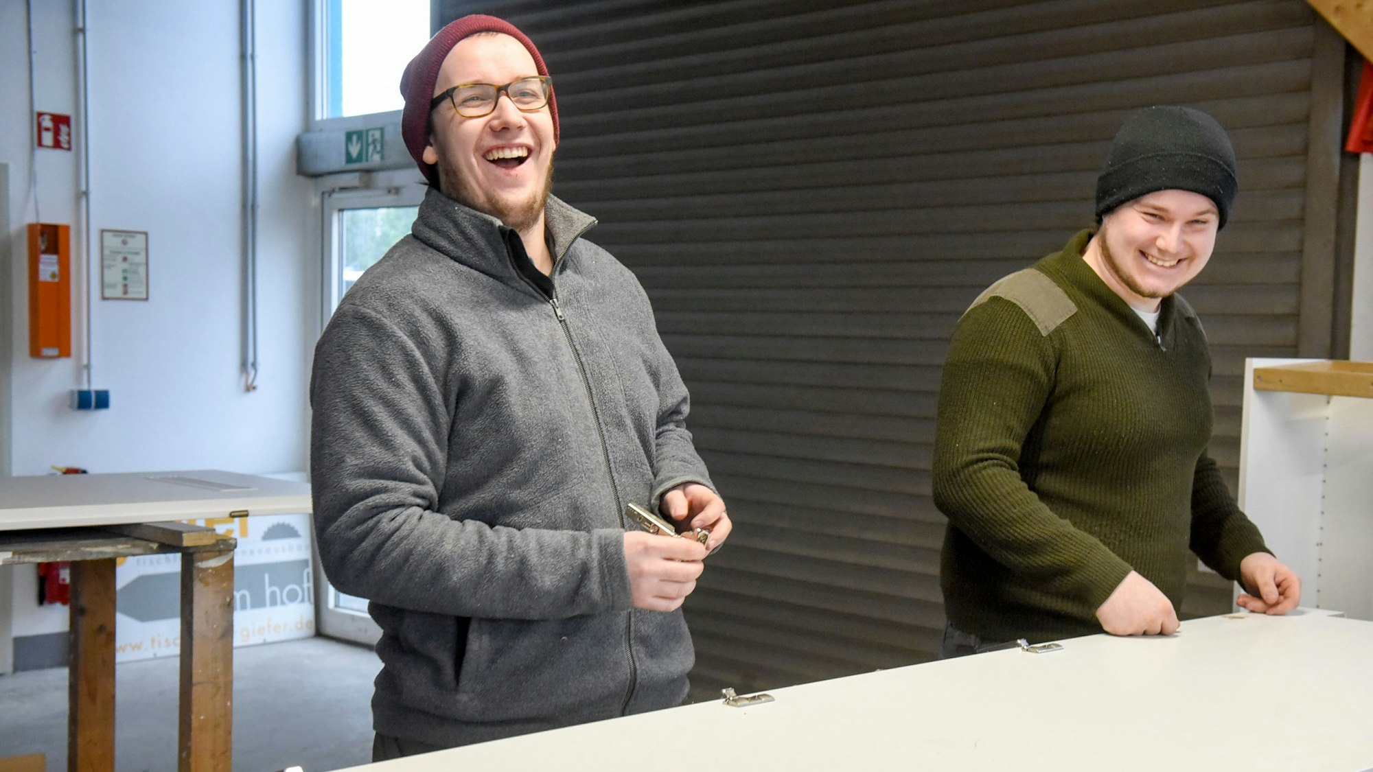 Auf dem Bild sind zwei Handwerker in der Werkstatt zu sehen.