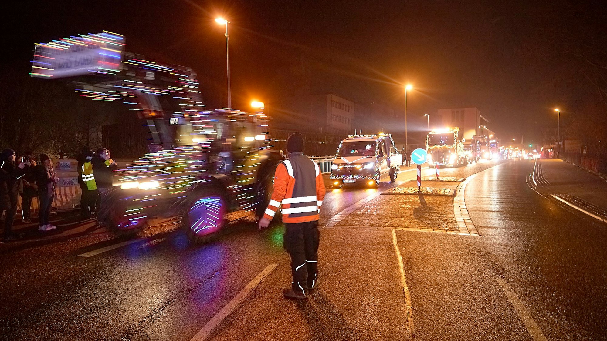 Vorne ist Christian Stoll von hinten zu sehen. Die Fahrzeuge fahren an ihm vorbei.