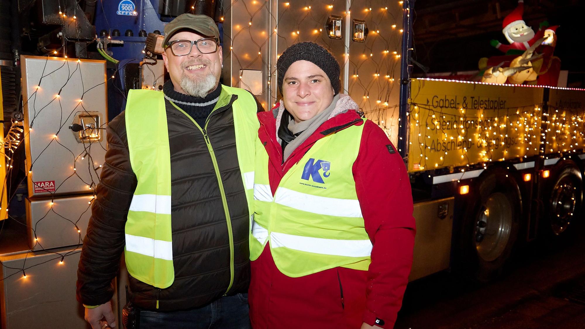 Georg Schmitz und Sandra Hamacher stehen vor einem leuchtenden Wagen