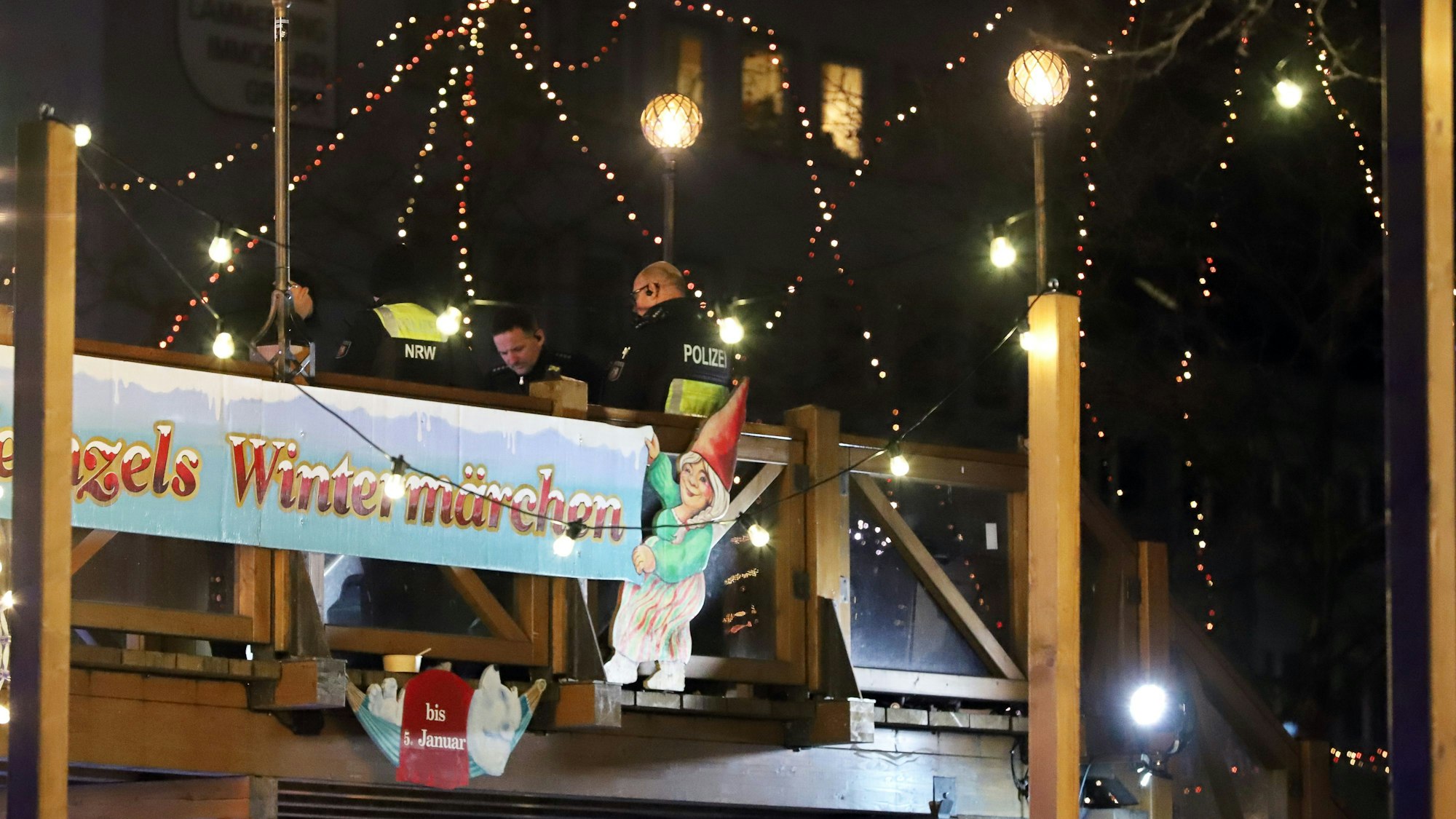 Köln: Polizeikräfte stehen auf einem Weihnachtsmarkt in der Innenstadt auf einer Brücke, auf der ein verdächtiger Koffer gefunden wurde.