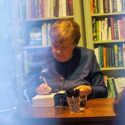 Angela Merkel signiert ihr Buch Freiheit.