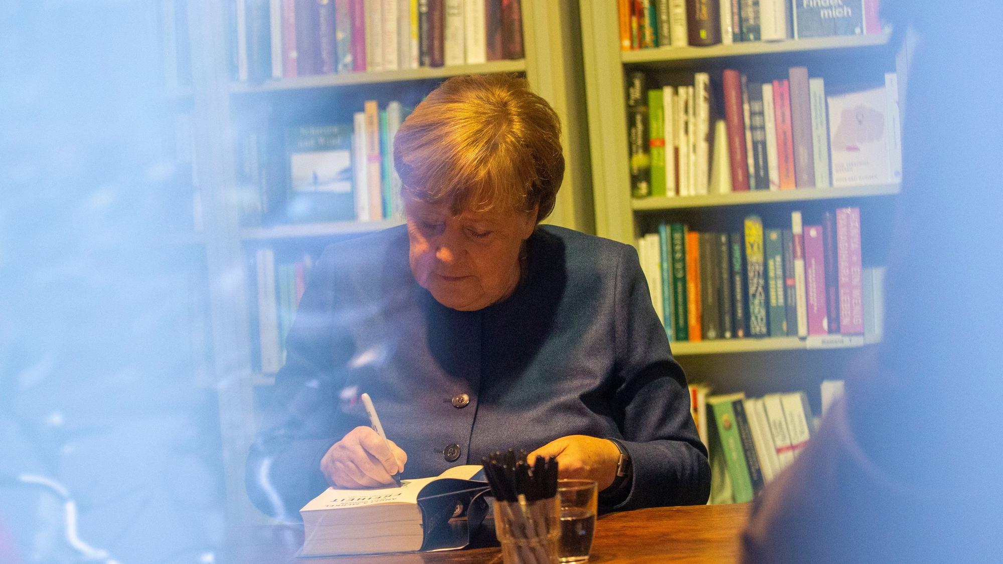 Angela Merkel signiert ihr Buch Freiheit.