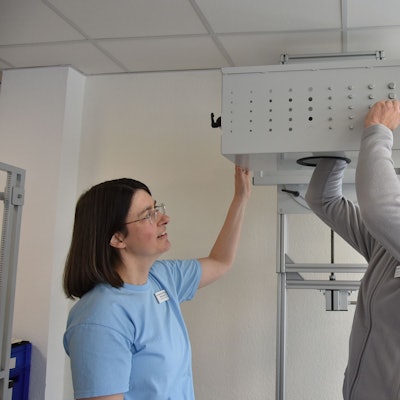 Der Leiter des Therapiezentrums, Ulrich Häussermann, demonstriert unter den kritischen Blicken der Bereichsleiterin Ergotherapie, Heike Oppenberg, wie Über-Kopf-Arbeiten trainiert wird.