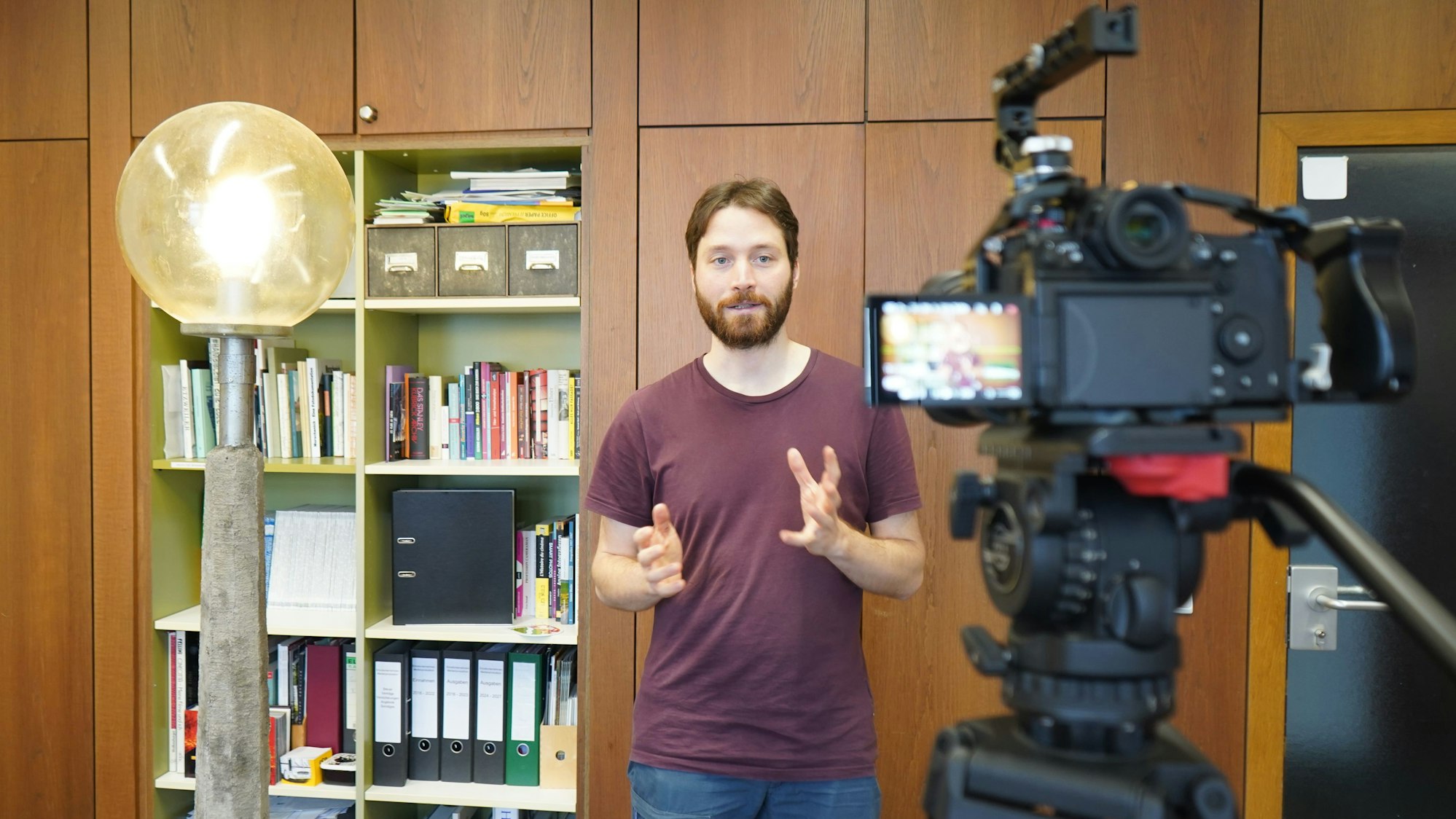 Das Foto zeigt einen jungen Mann vor der Kamera.