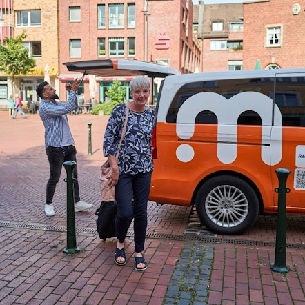 Eine Frau ist gerade aus einem Elektro-Kleinbus ausgestiegen.