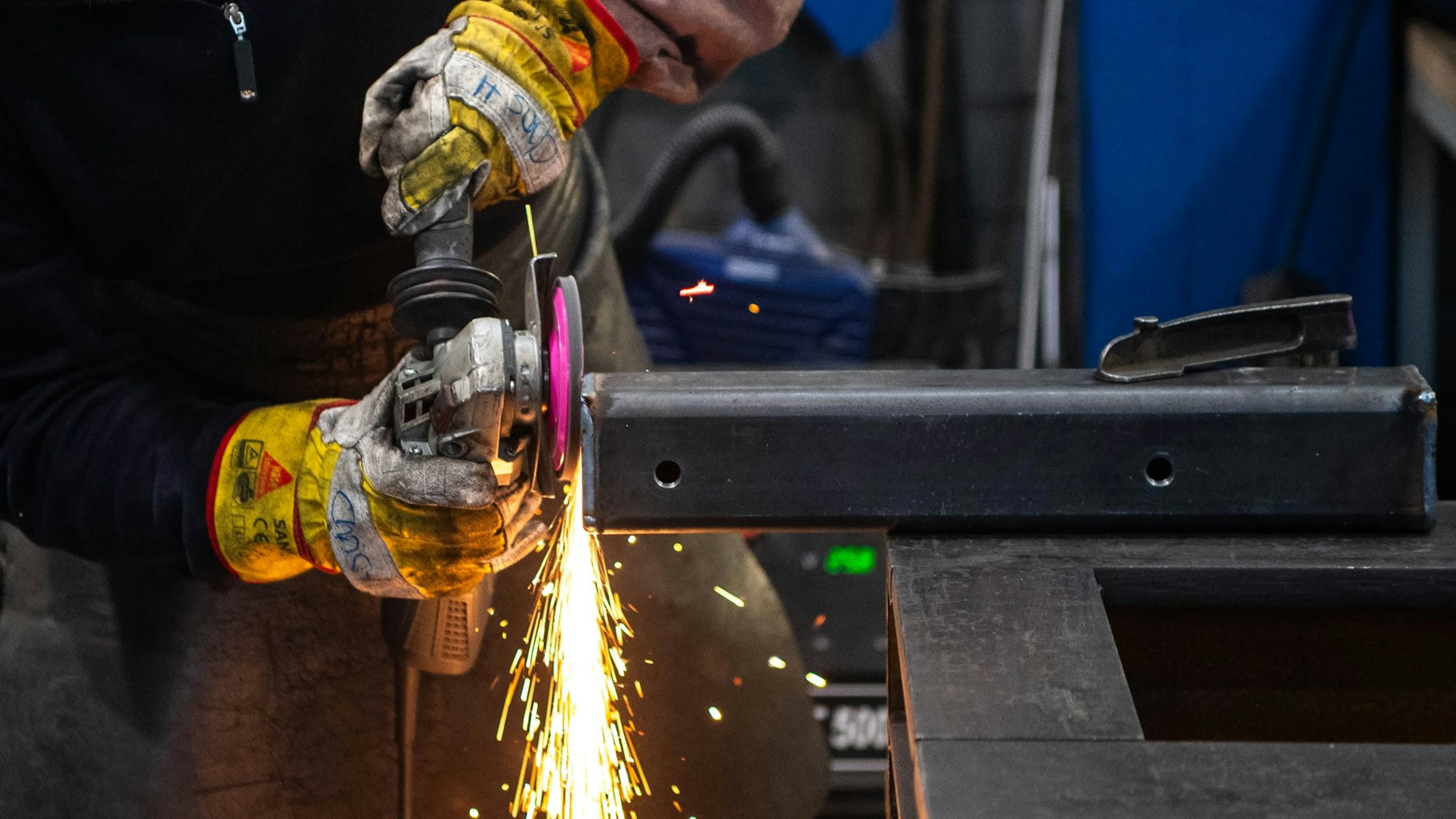 Das Bild zeigt Funken, die fliegen, weil ein Metallpfosten abgeschliffen wird.