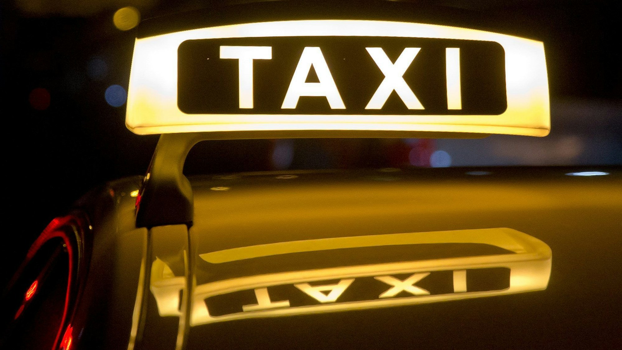 Ein Taxi steht im Dunkeln für Fahrgäste bereit.