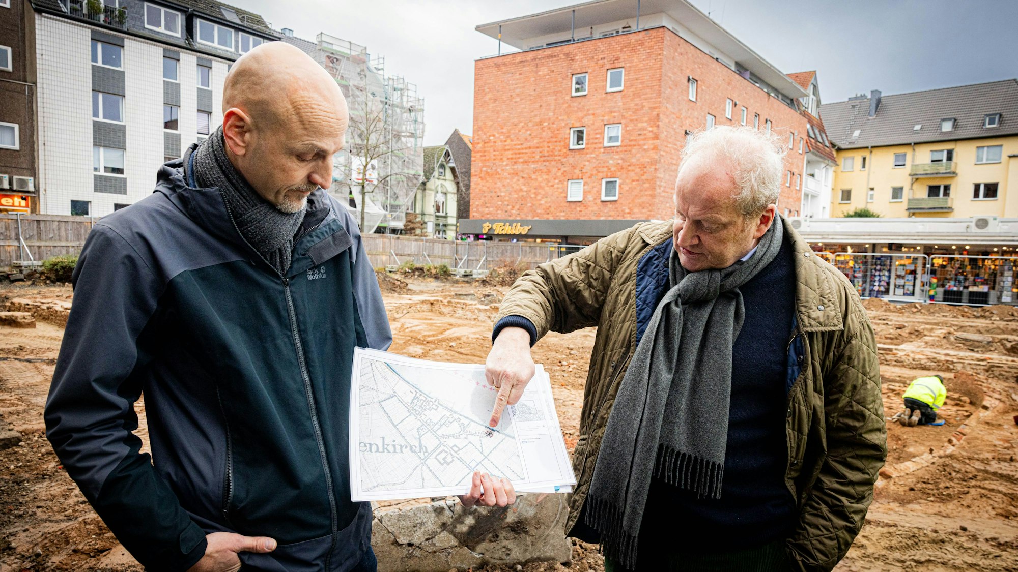 Prof. Dr. Marcus Trier vom Römisch-Germanischen Museum und Gregor Wagner von der archäologischen Bodendenkmalpflege erklären anhand von historischen Karten die Lage des Hofes.