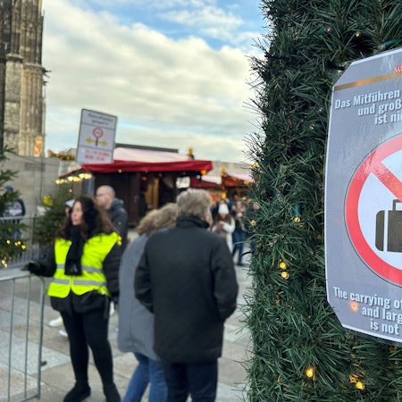 Ein Hinweisschild weist am Roncalliplatz auf das geltende Kofferverbot hin.